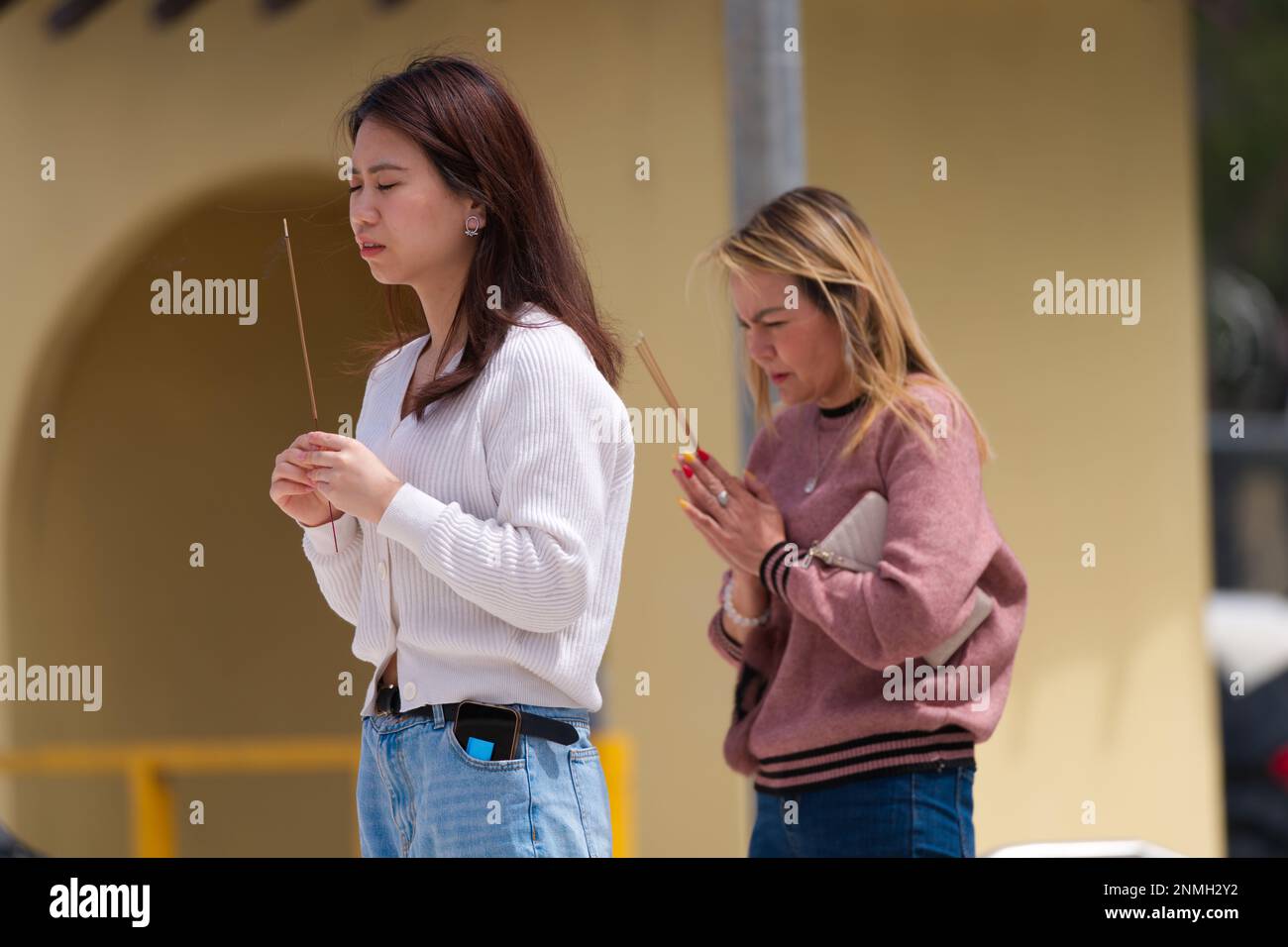 Zwei Frauen beten und bedanken sich mit Weihrauch im vietnamesischen buddhistischen Tempel Quang Minh, Melbourne, Australien. Stockfoto