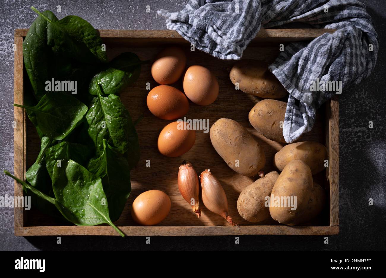 Bamberger Hoernla, auch Bamberger Hoernchen, eine alte Kartoffelsorte aus Franken, Kartoffeln, mit Eiern und Spinat, auf einem Holztablett, Lebensmittelfotografie Stockfoto