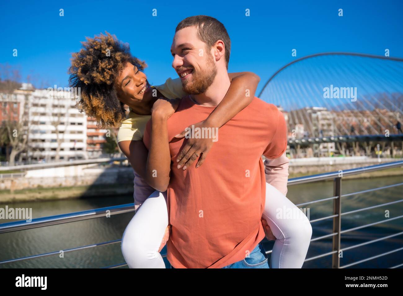 Multirassisches Paar auf der Straße, Lifestyle, lächelnd mit Freundin auf dem Laufsteg Stockfoto