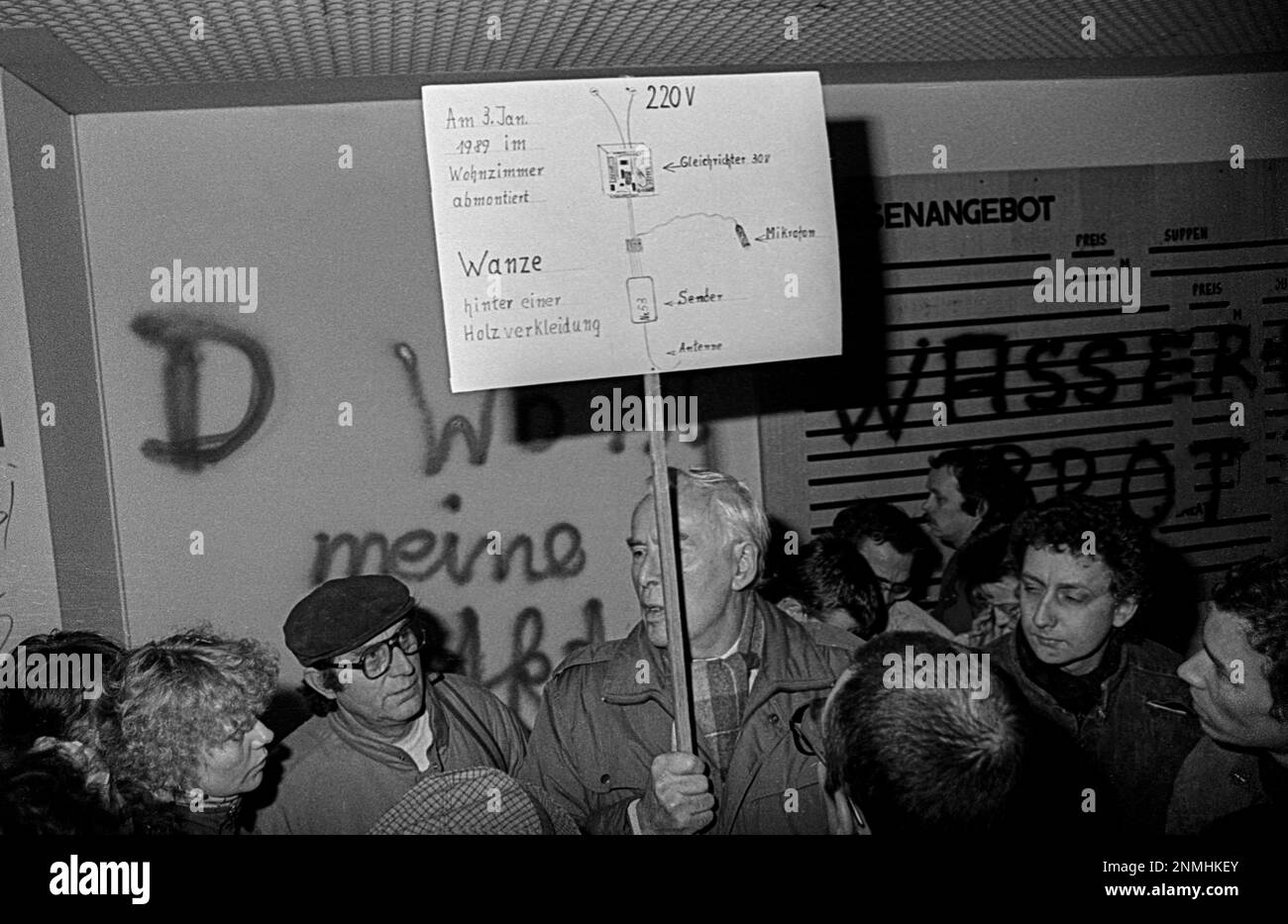 DDR, Berlin, 15.01.1990, Besetzung des Stasi-Hauptquartiers in der Normannenstraße, ein Bürger hält ein Schild mit dem Versteck einer Wanze Stockfoto