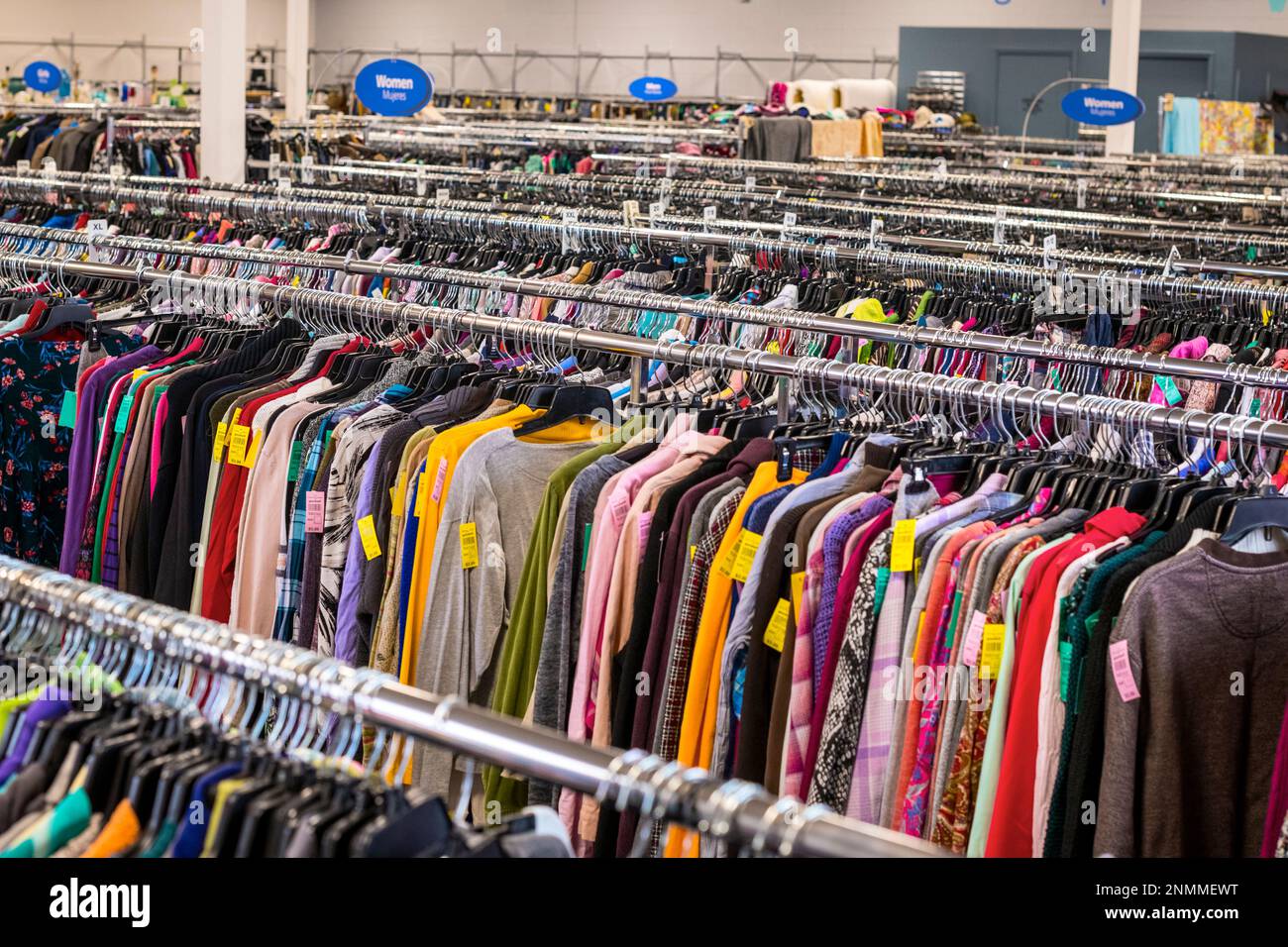 Mehrere Kleiderständer in einem Second-Hand-Geschäft in Ludington, Michigan, USA. Stockfoto