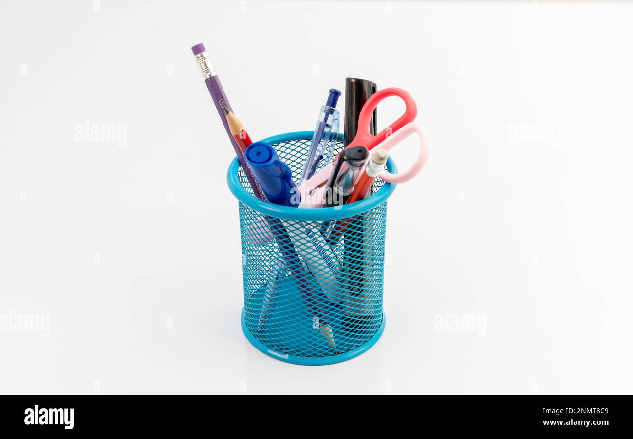 Schreibwaren in blauem Netzhalter isoliert auf weißem Hintergrund Stockfoto