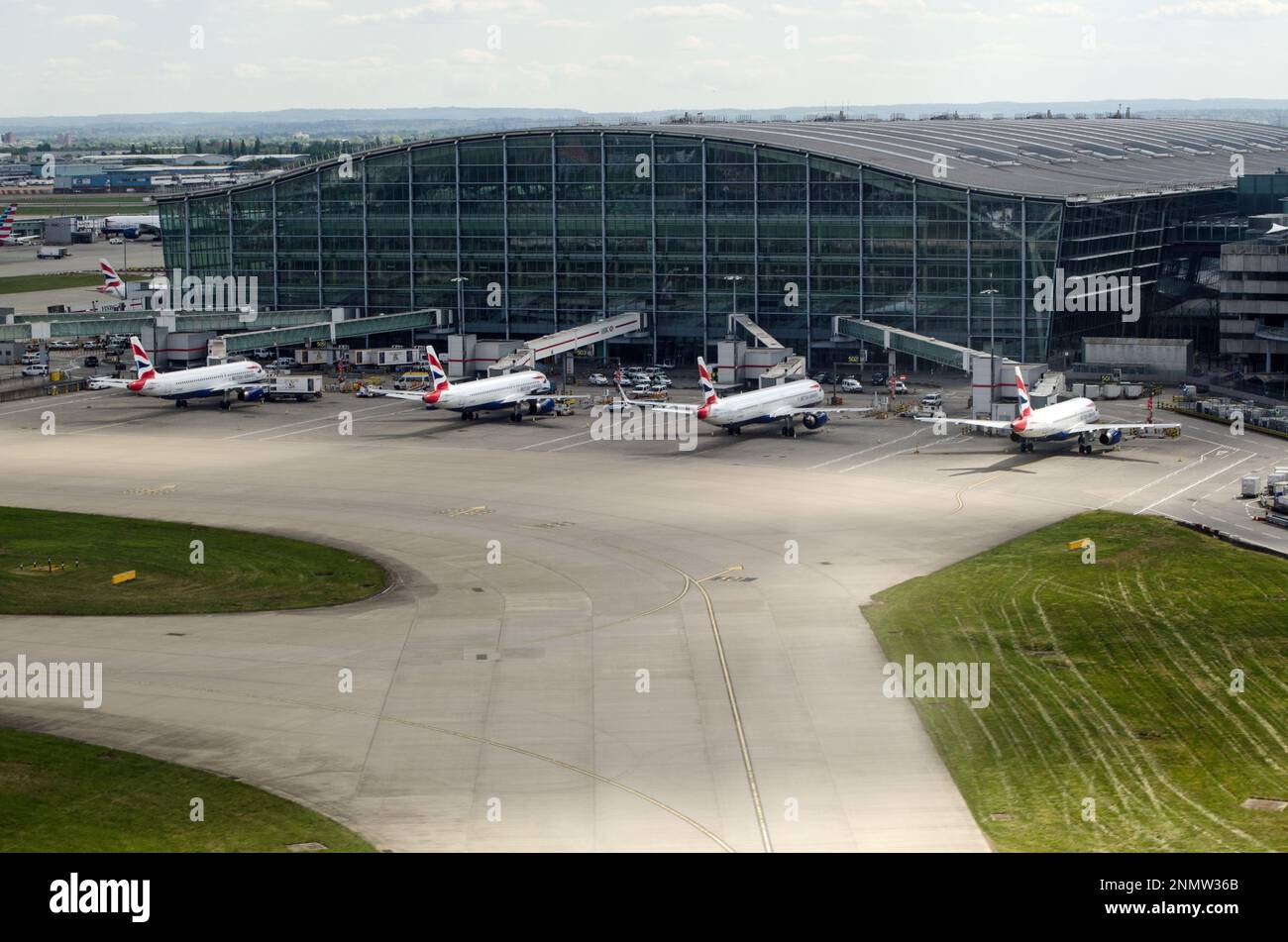 Heathrow, Großbritannien - 26. April 2022: Luftaufnahme von Terminal 5 am Flughafen Heathrow. Flugzeuge von British Airways warten an einem Frühlingsnachmittag auf die Passagiere. Stockfoto