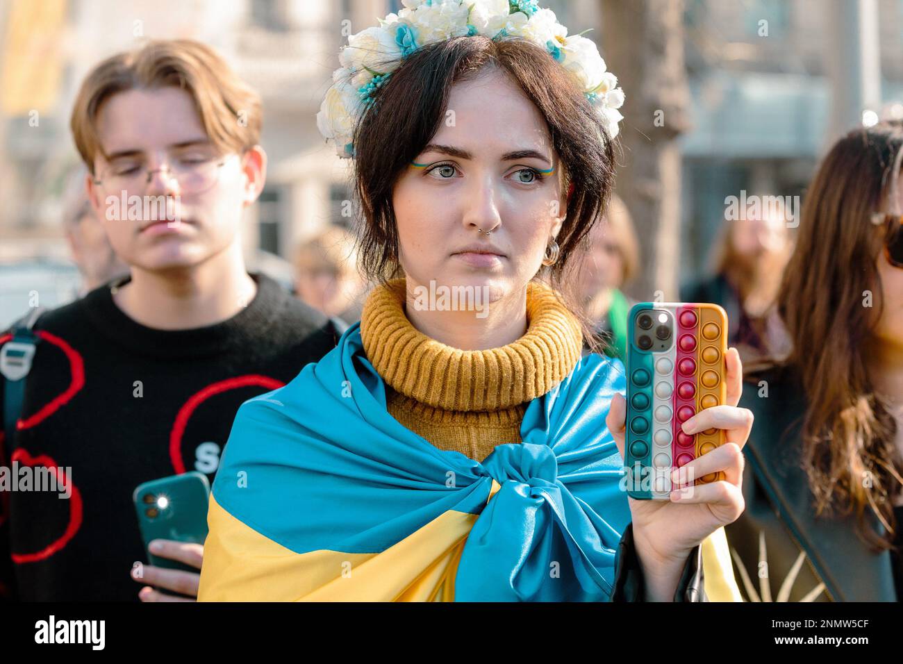 Istanbul, Türkei. 24. Februar 2023. Eine junge Frau mit der ukrainischen Flagge hält während einer Anti-Kriegs-Demonstration in Istanbul ihr Telefon auf die Aufzeichnung. Demonstranten versammeln sich in Zentral-Istanbul, der Türkei, um den einjährigen Jahrestag der russischen Invasion der Ukraine zu begehen. Nach einem Jahr russischer Invasion geht der Kampf weiter. Kredit: SOPA Images Limited/Alamy Live News Stockfoto