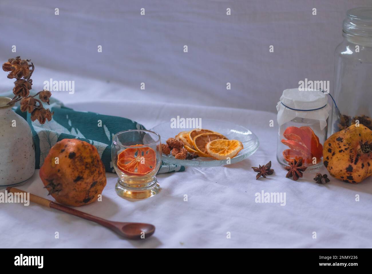 Getrocknete Zitronenscheiben und Aromaten auf einer Platte zur Vorbereitung auf eine entspannende Aromatherapie zu Hause Stockfoto