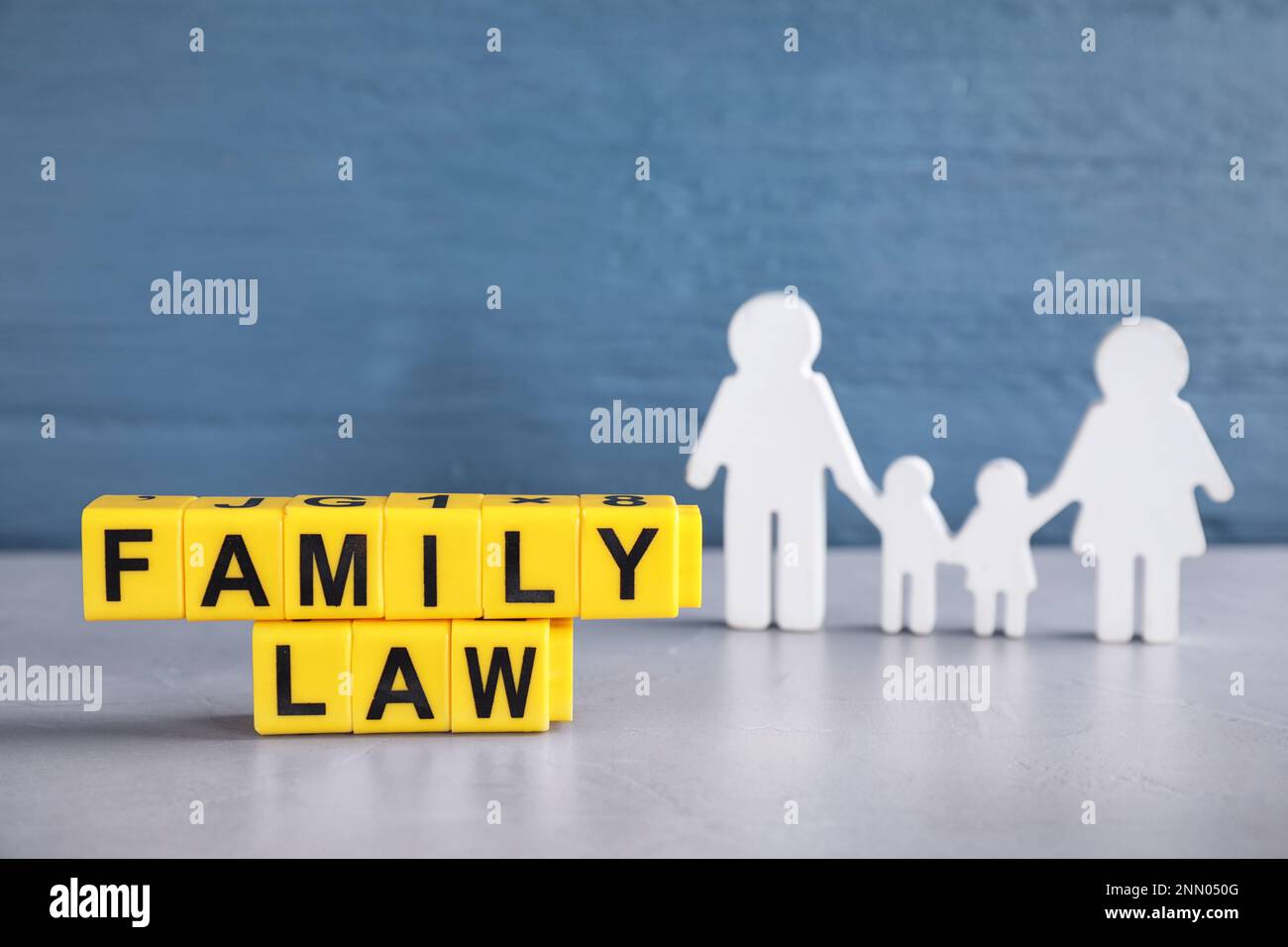 Würfel mit Buchstaben und Familienfigur auf dem Lichttisch. Familienrechtsbegriff Stockfoto