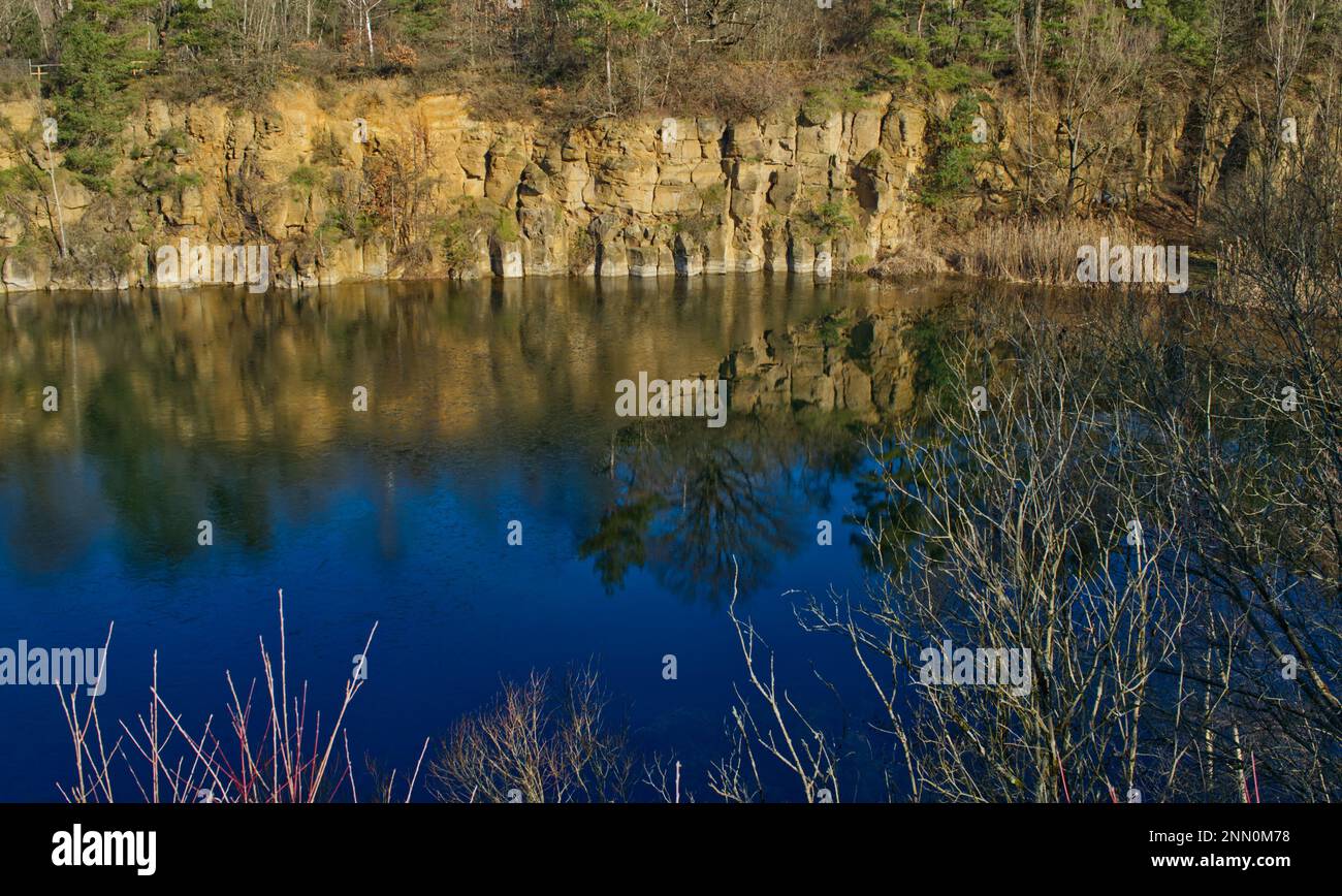 Landschaft einer Felswand im Naturschutzgebiet „Grüner See“ (grüner See) eines ehemaligen Steinbruchs in Mühlheim-Dietesheim, Hessen, Deutschland Stockfoto