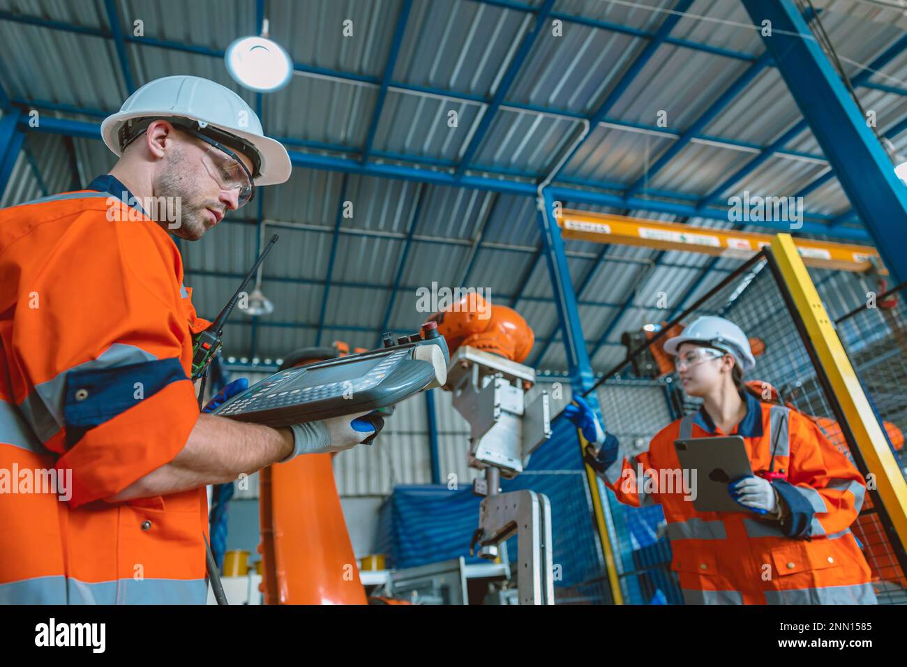 Ingenieurteam Serviceprogrammierung automatisierter Schweißarm für Roboterschweißen in modernen Schwerindustrie-Fabriken Stockfoto