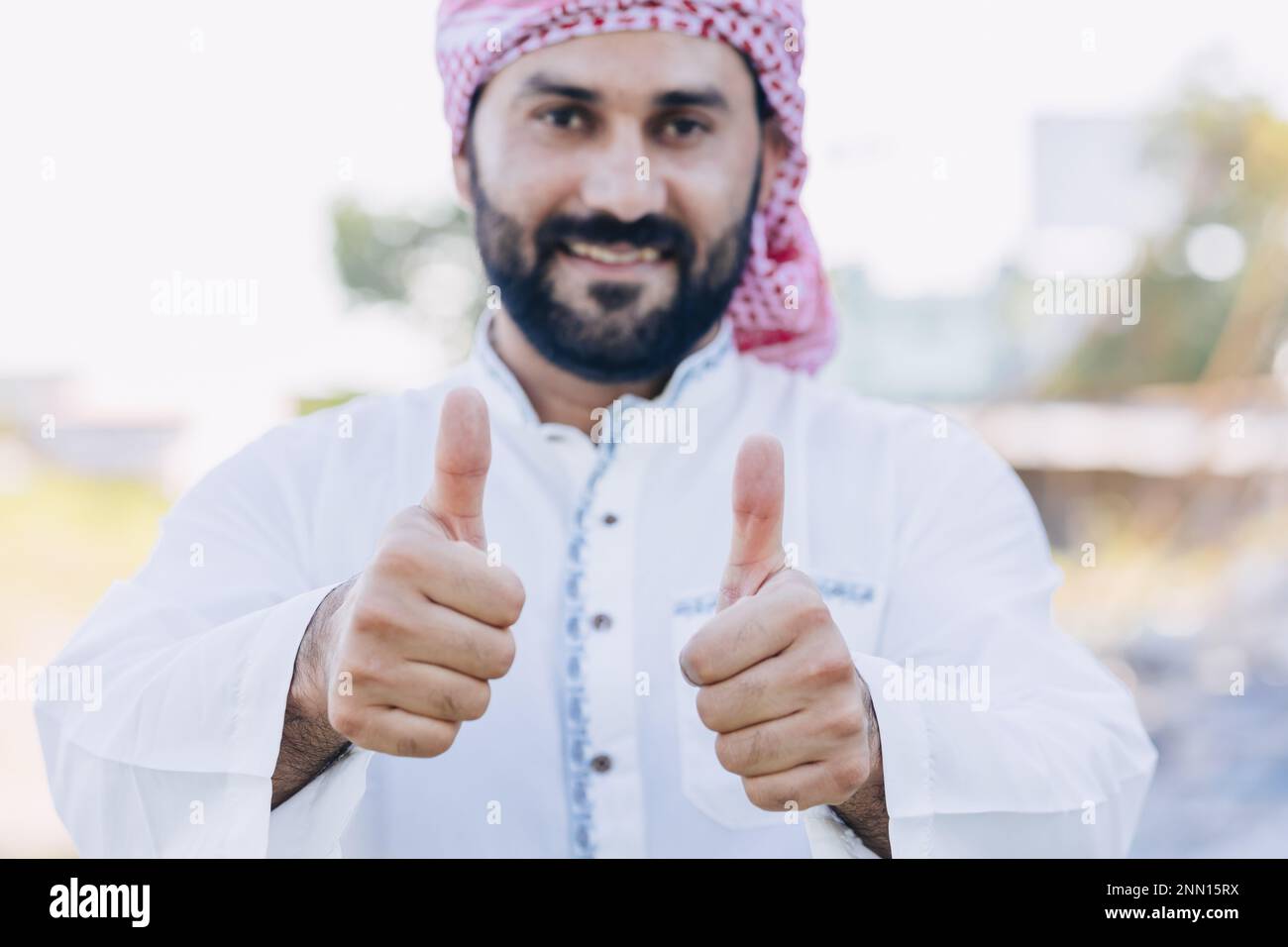 Arub muslimischer Erwachsener männlich glücklich lächelnd Daumen nach oben und sieht aus wie eine Nahaufnahme Stockfoto