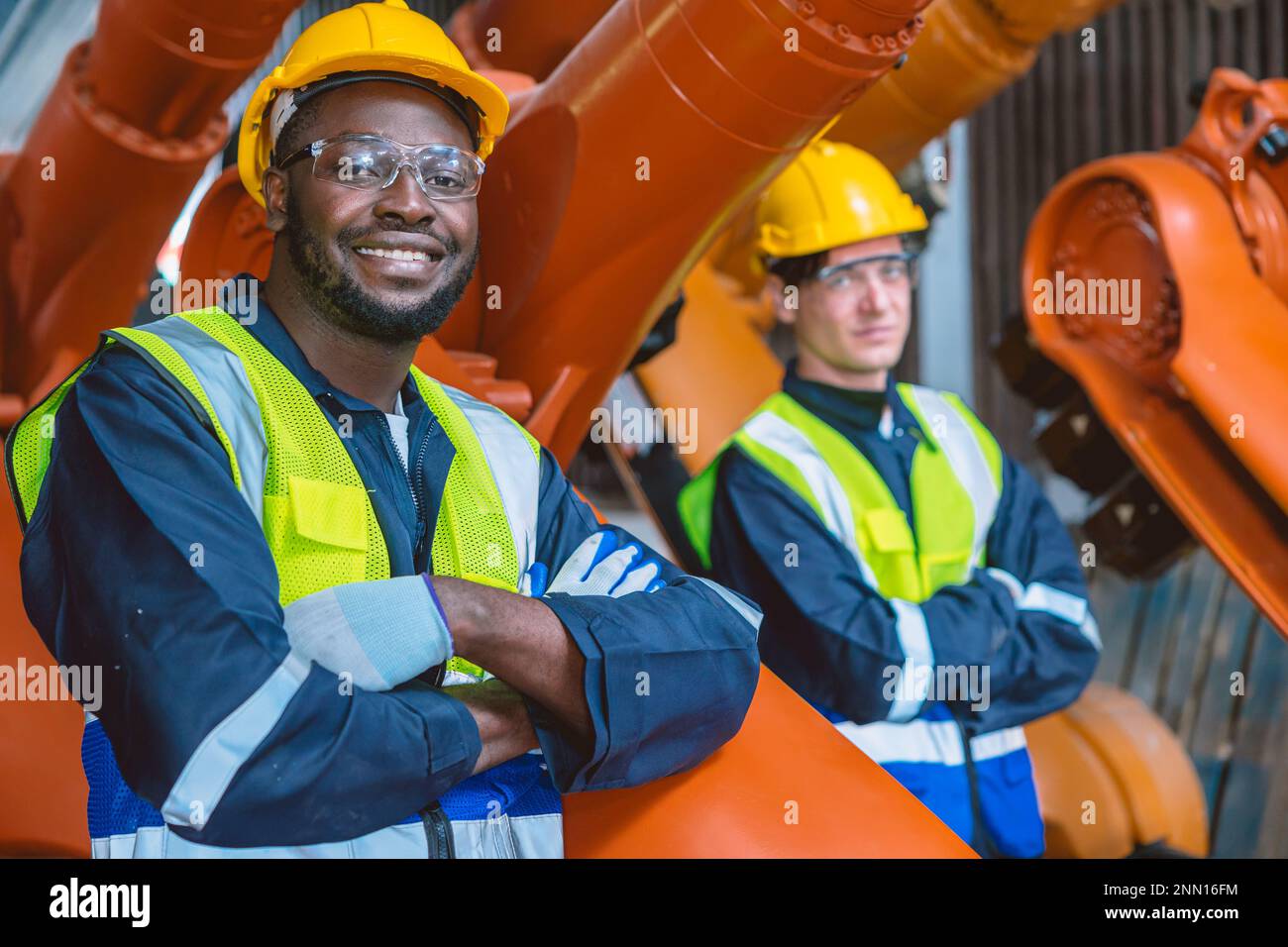 Schwarzer afrikanischer Ingenieurmitarbeiter in der Roboterarmenfabrik. Service-Teamwork-Mann. Stockfoto