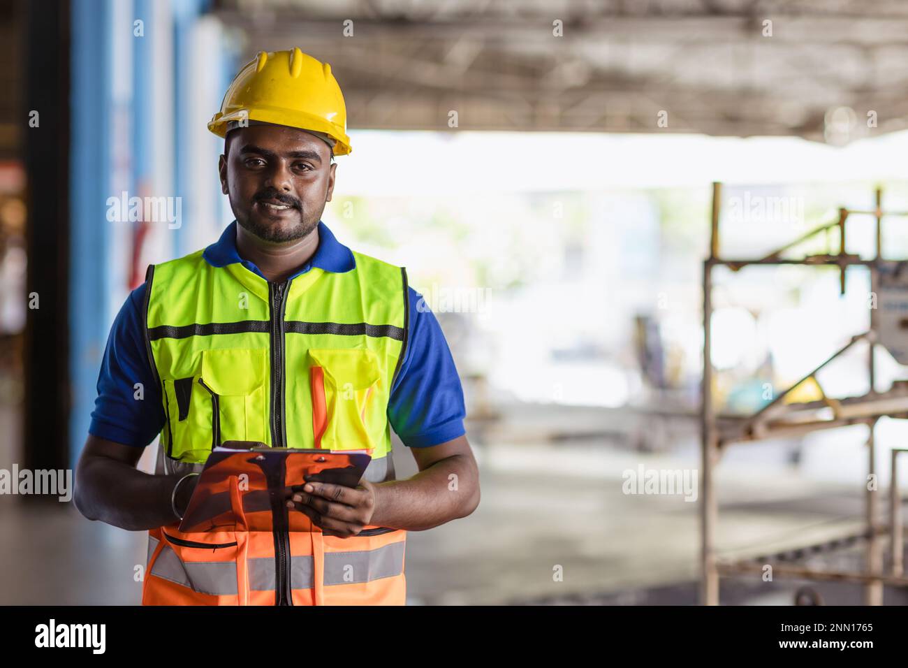 Portrait Indischer männlicher Mitarbeiter Ingenieur Vorgesetzter für Sicherheitsanzüge Arbeit im Fabriklager Stockfoto