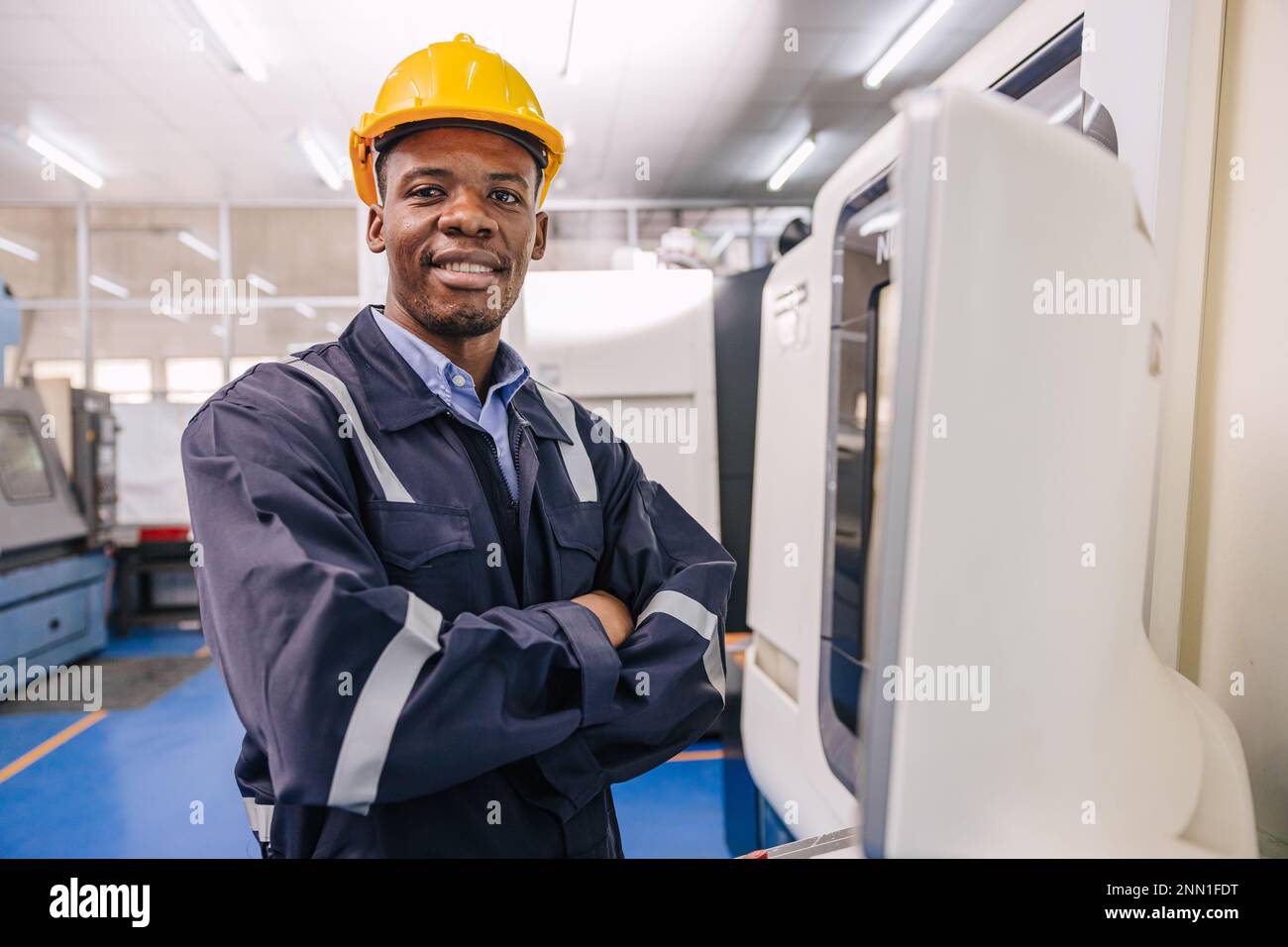 Portrait intelligenter schwarzer afrikanischer Ingenieur, der mit cnc-Drehmaschine in einer modernen Metallfabrik arbeitet Stockfoto