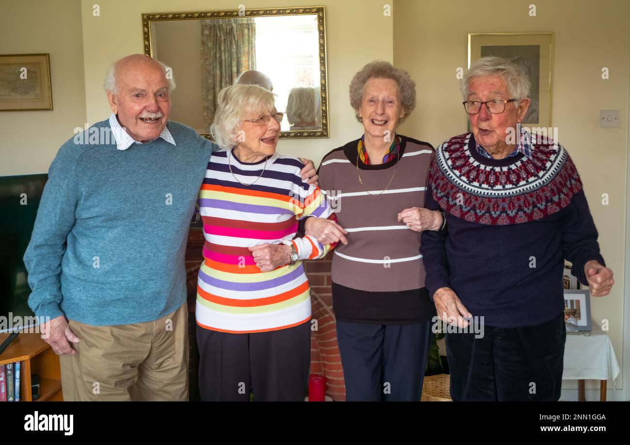 Vier lebenslange nicht-Agenarier-Freunde, die sich seit mehr als 70 Jahren kennen, lächeln und posieren für die Kamera Stockfoto