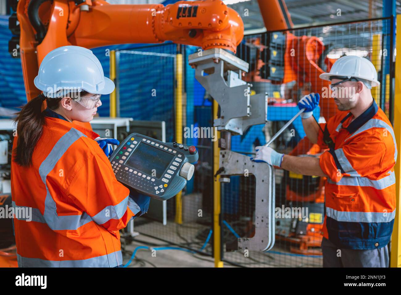 Techniker-Team-Mitarbeiter warten Roboterarm-Montagemaschine in einem modernen Metallwerk Stockfoto