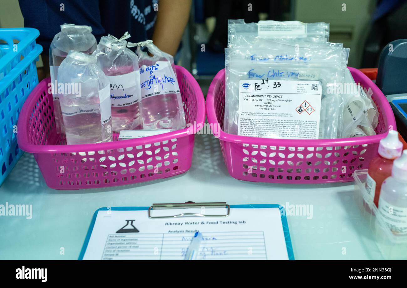 Kunststoffkörbe in einem Wasserprüflabor in Kambodscha mit Wasserproben und Reagenziensätzen. Stockfoto