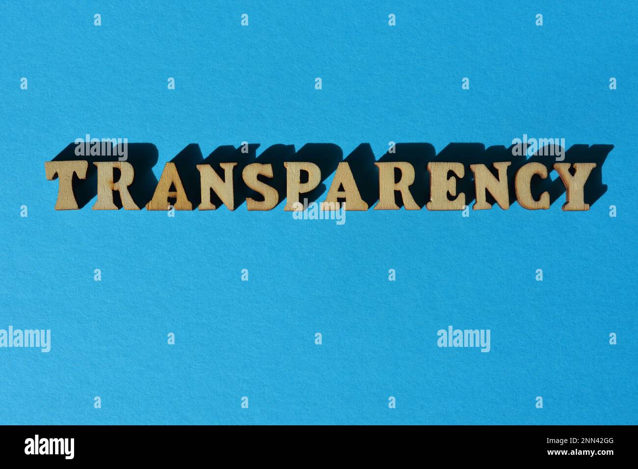 Transparenz, Wort in hölzernen Buchstaben isoliert auf blauem Hintergrund Stockfoto