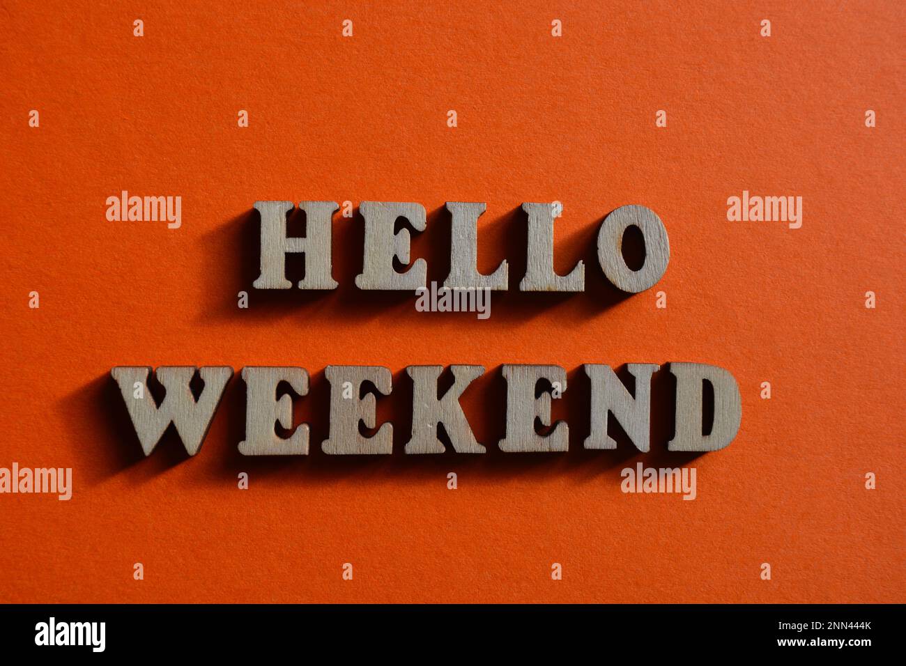 Hallo Wochenende, Wörter in hölzernen Buchstaben isoliert auf orangefarbenem Hintergrund Stockfoto