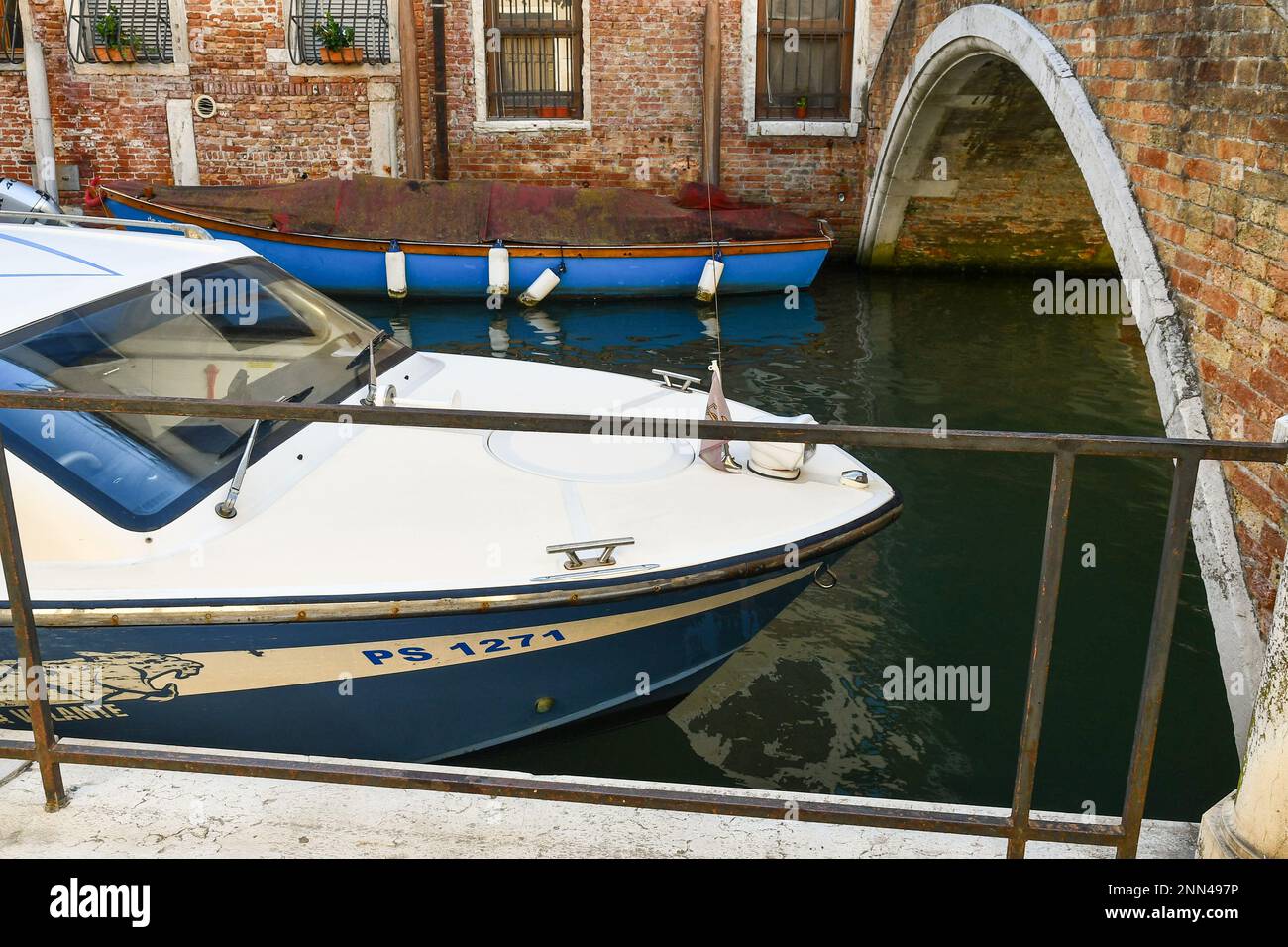 Der Bug eines venezianischen Polizeiboots, das auf dem Kanal Rio di San Felice neben der Bogenbrücke Ponte Racheta, Cannaregio, Venedig, Veneto, Italien vor Anker liegt Stockfoto