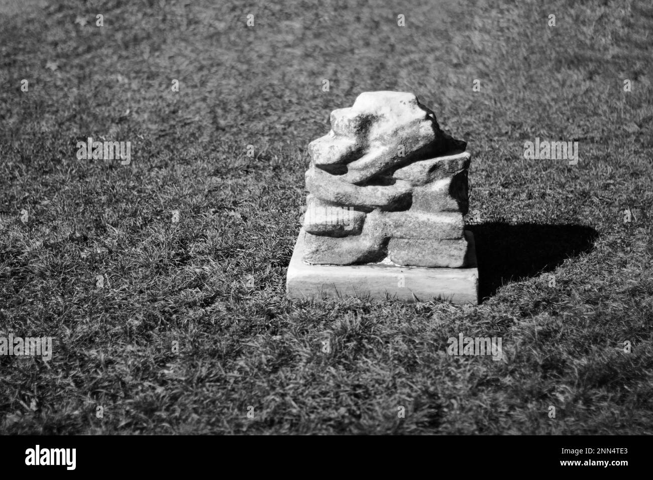 Ein klassischer Natursteingräber mit einem Steinhecht und Stein in Schwarz-Weiß-Monochrom. Stockfoto