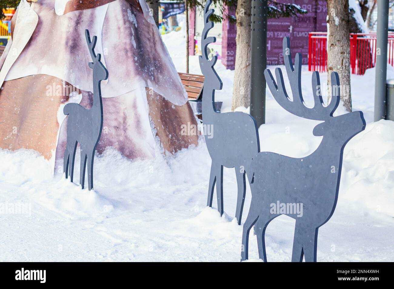 Skulptur von Hirschen und Wigwam als Winterdekoration des Parks. Städtischer Freizeitpark mit Tierfiguren auf weißem, reinem Schneehintergrund, selektiv Stockfoto