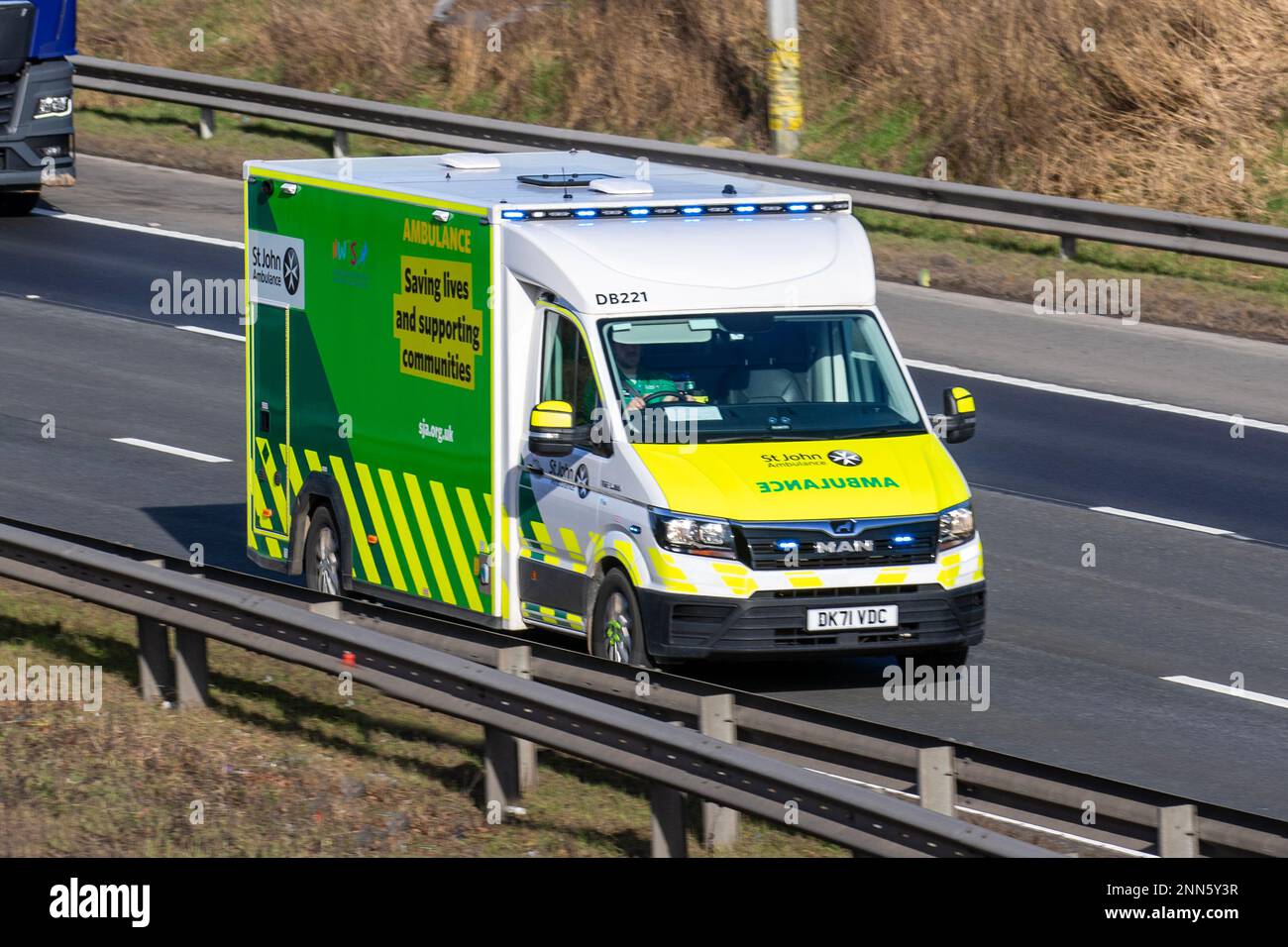 St. John Ambulance fährt auf der Überholspur der Autobahn M6 mit blauen Ampeln und Sirenen, Manchester, Großbritannien Stockfoto