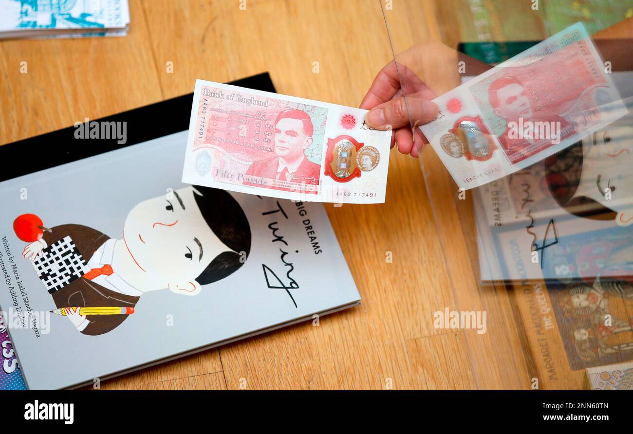 Sarah John, chief cashier of the Bank of England, holds a new 50 pound bank note over a book about World War II code breaker Alan Turing at Daunt Books in London, Wednesday, June 23, 2021. The new note features code breaker Alan Turing. (Hollie Adams/Pool via AP) Stockfoto