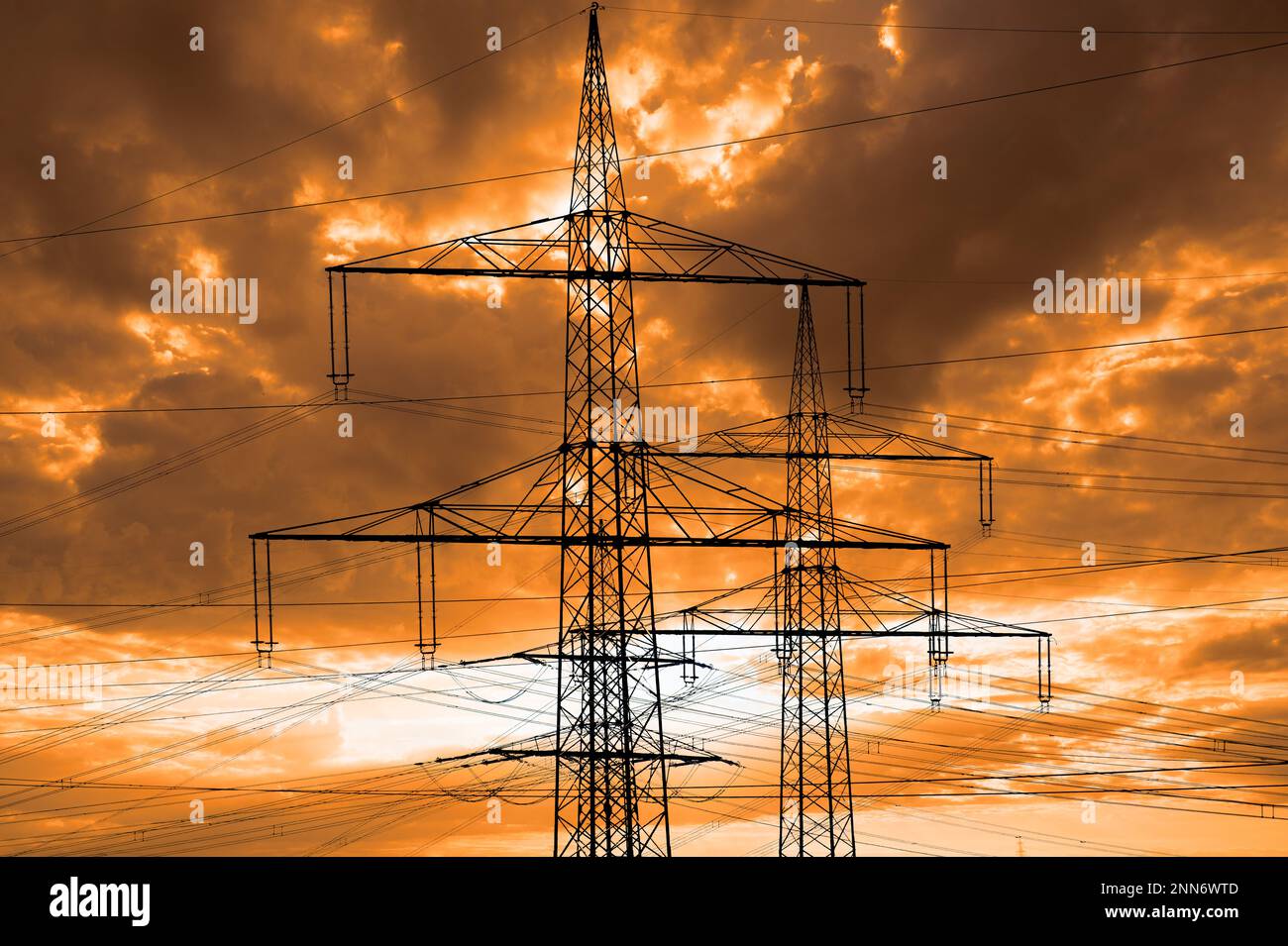 Hochspannungsmasten für Elektrizität und Kraft gegen den Himmel mit dramatischen Wolken Stockfoto