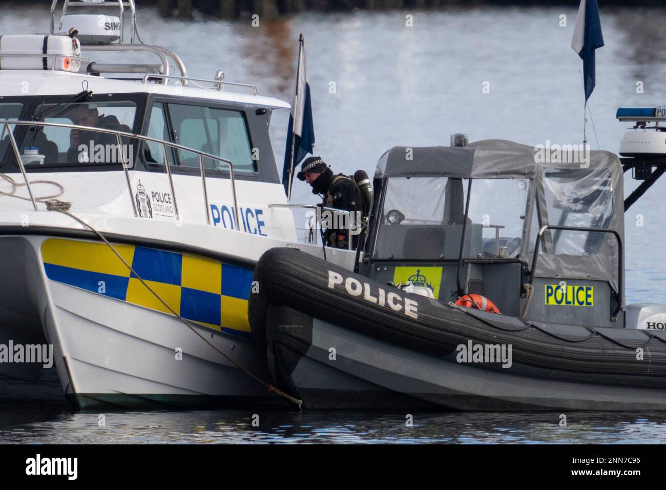 Greenock, Schottland, Großbritannien. 25. Februar 2023 Polizei und Pilot am Ort des Untergangs des Clyde Marine Services Tubs Biter, der gestern in Greenock in der Nähe des Ost-Indien-Hafens gesunken ist. Zwei Crewmitglieder werden immer noch vermisst. Bild: Polizeitaucher arbeiten über dem versunkenen Schlepper. Iain Masterton/Alamy Live News Stockfoto