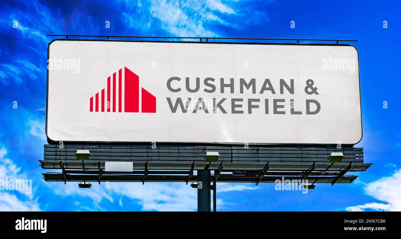 POZNAN, POL – 8. FEBRUAR 2023: Reklametafel mit Logo von Cushman und Wakefield, einem globalen gewerblichen Immobiliendienstleistungsunternehmen mit Sitz in Stockfoto