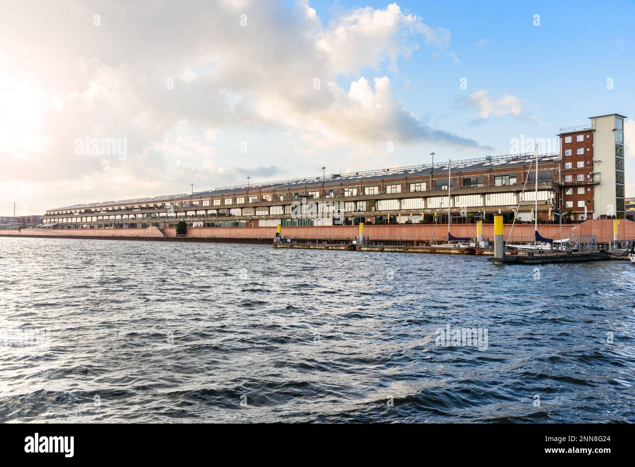 Renoviertes altes Lagerhaus entlang eines ehemaligen Hafens bei Sonnenuntergang im Sommer Stockfoto