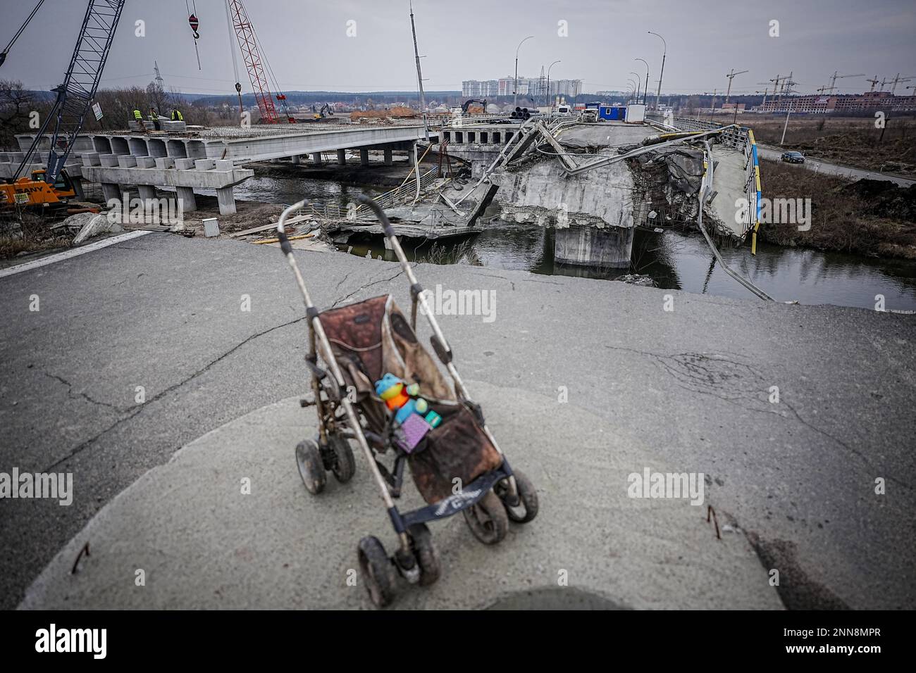 Irpin, Ukraine. 25. Februar 2023. Ein Kinderwagen steht auf der Brücke, die während des Krieges zerstört wurde, auf der arteriellen Straße von Irpin bei Kiew. Die Brücke ist in vollem Gange. Kredit: Kay Nietfeld/dpa/Alamy Live News Stockfoto