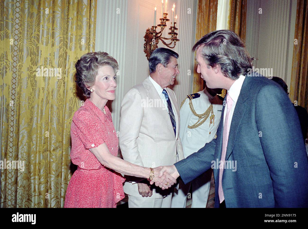 Präsident Ronald Reagan und Nancy Reagan begrüßen Donald Trump (rechts) im State Dining Room des Weißen Hauses während eines Empfangs für Eureka College Stipendiaten, Washington, DC, 8/4/1983. (Foto vom Fotobüro des Weißen Hauses Stockfoto