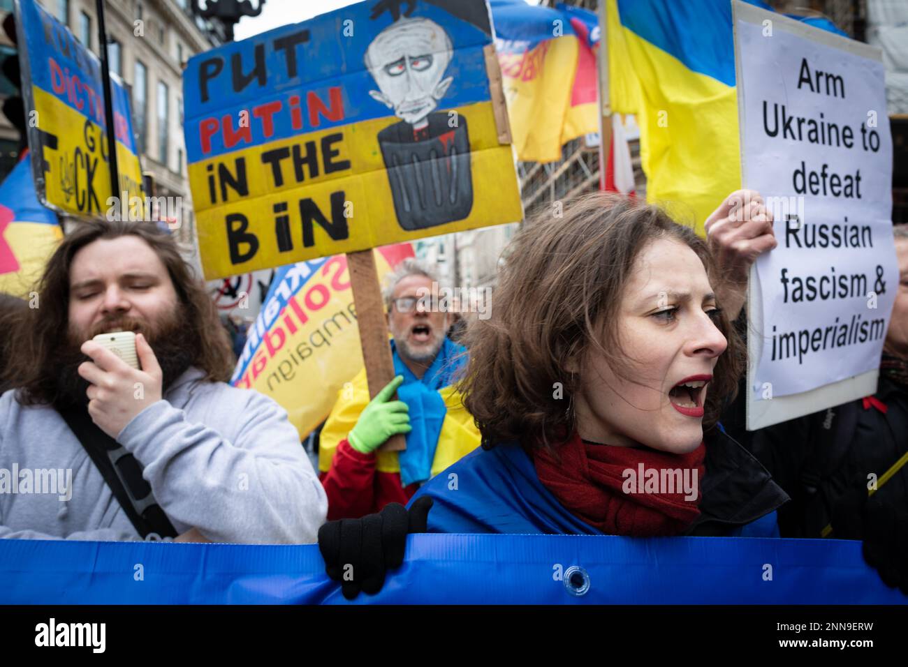 London, Großbritannien. 25. Februar 2023. Ukrainische Anhänger marschieren durch die Stadt, um die NATO bei der Niederlage Russlands zu unterstützen. Vor einem Jahr marschierte Russland in die Ukraine ein und tötete Tausende von Menschen. Die Stop the war-Bewegung möchte Friedensgespräche führen, nicht die Bewaffnung eines andauernden Krieges, der nur Waffenproduzenten zugute kommt. Kredit: Andy Barton/Alamy Live News Stockfoto