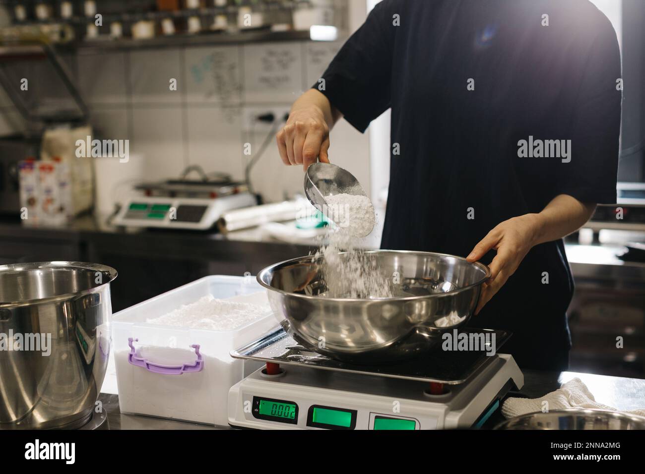 Eine Köchin arbeitet in einer modernen Industrieküche. Der Vorgang der Zubereitung von Kuchen in einer Bäckerei oder einem Café. Stockfoto