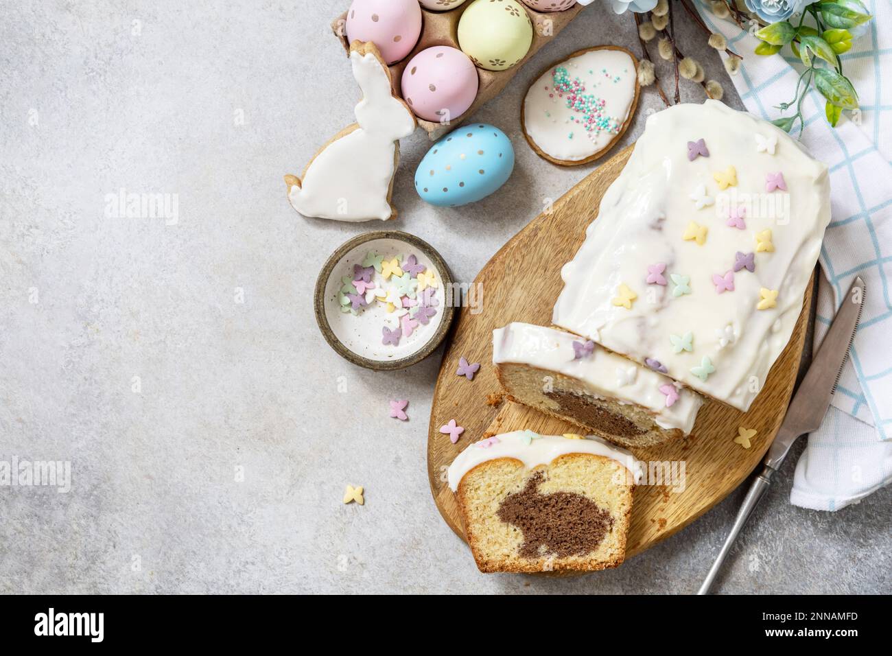 Frohes Osterferienessen, Cupcake mit Osterhasen und bunten Eiern auf Steinhintergrund. Blick von oben. Speicherplatz kopieren. Stockfoto