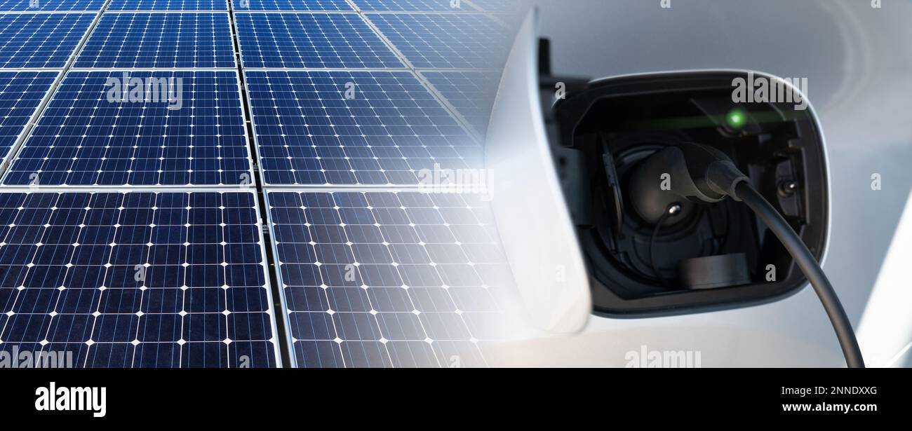 Nahaufnahme eines Elektroautos mit Ladekabel und Solarmodulen Stockfoto