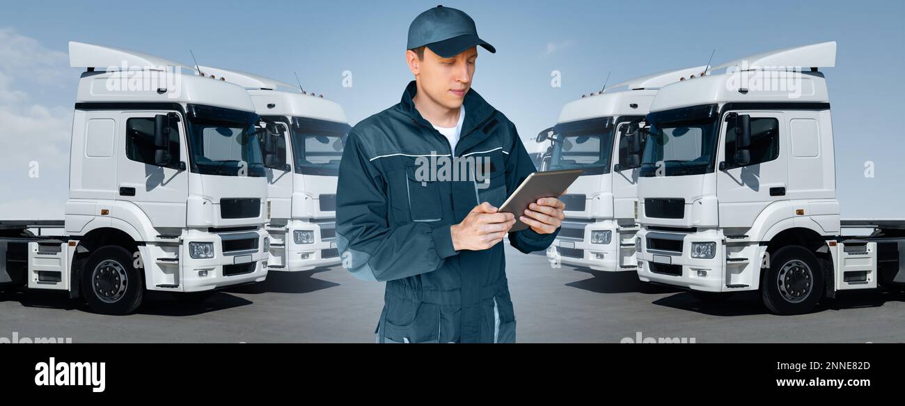 Manager mit einem digitalen Tablet neben Trucks. Flottenmanagement Stockfoto