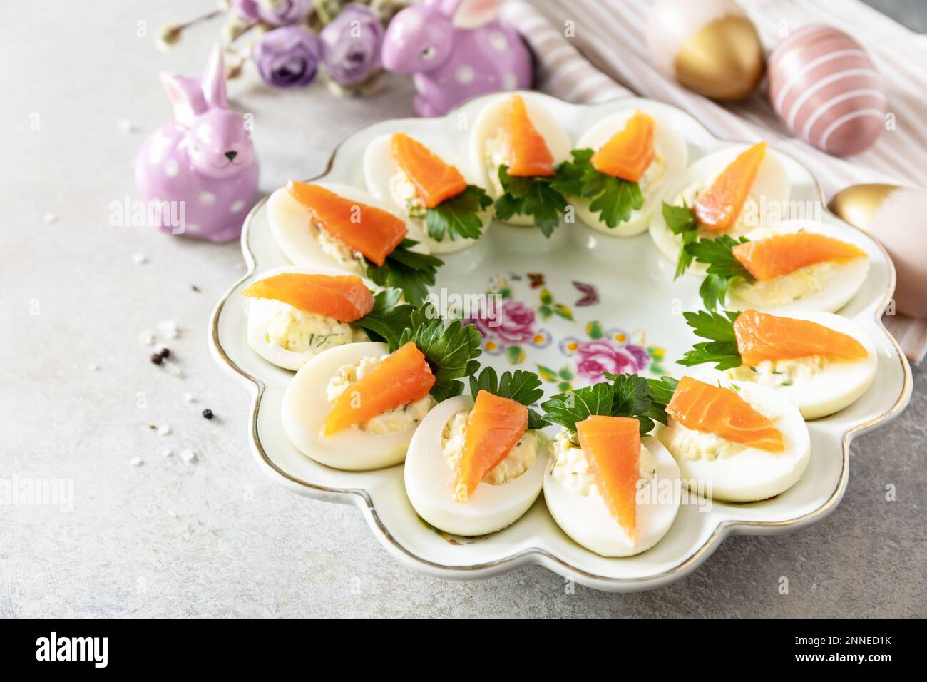 Festliches Abendessen, Osterbrunch. Gefüllte Eier mit Käse und gesalzener Lachs in Form einer Karotte. Speicherplatz kopieren. Stockfoto