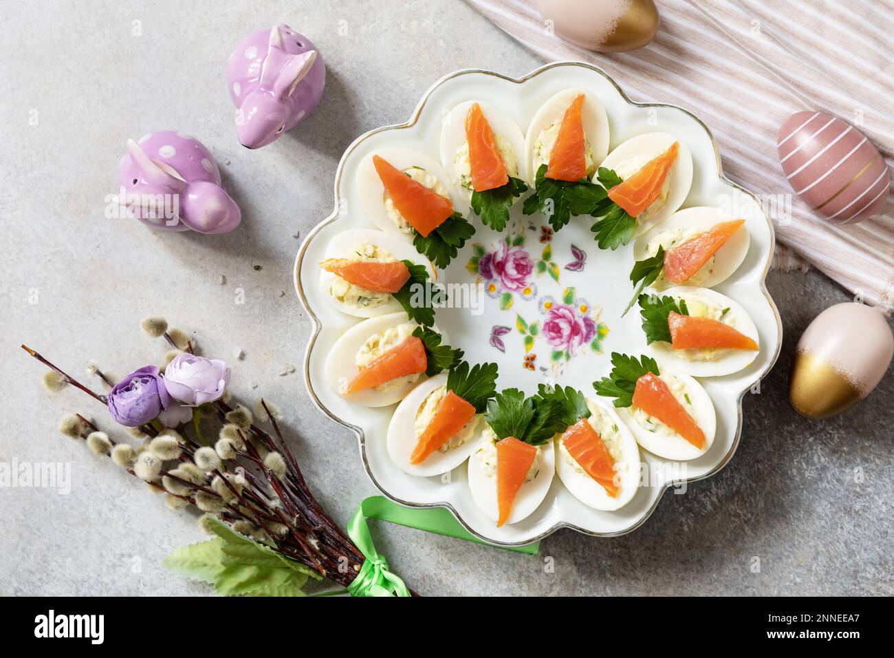 Festliches Abendessen, Osterbrunch. Gefüllte Eier mit Käse und gesalzener Lachs in Form einer Karotte. Blick von oben. Stockfoto