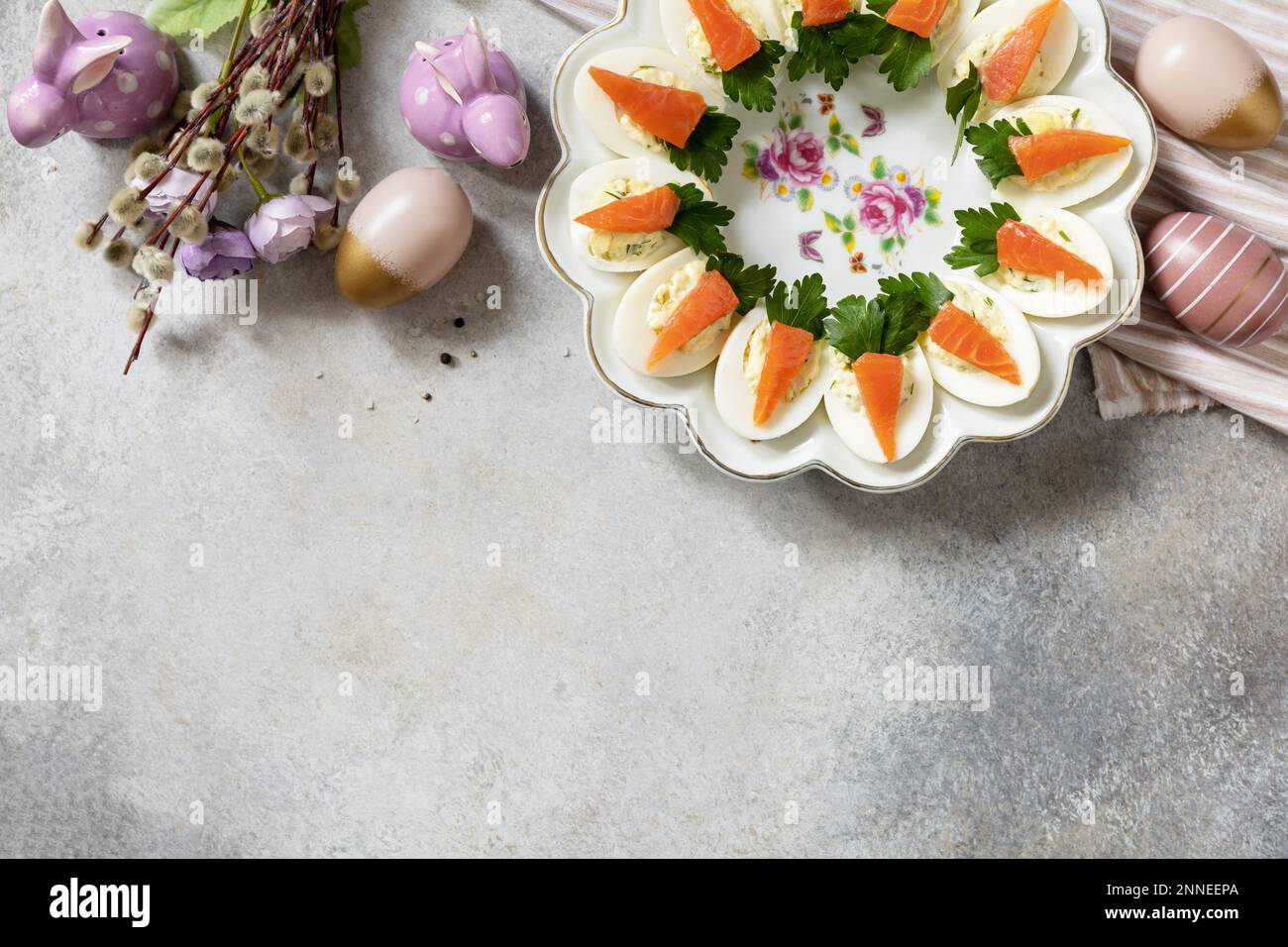 Gefüllte Eier mit Käse und gesalzener Lachs in Form einer Karotte. Festliches Abendessen, Osterbrunch. Blick von oben. Speicherplatz kopieren. Stockfoto
