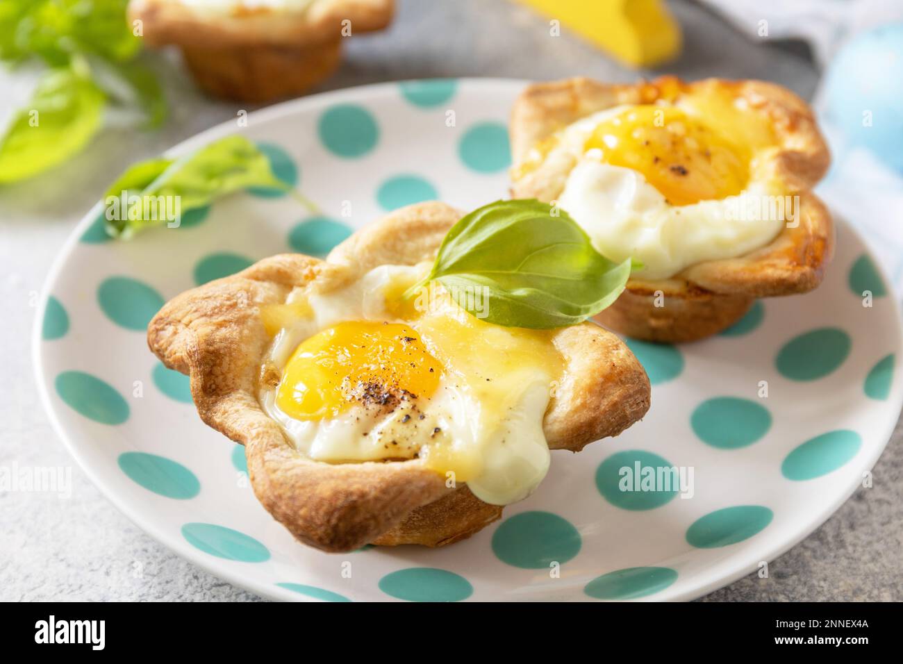Osterfrühstück-Idee. Rührei in Blätterteig mit Käse und Speck auf einem Steinhintergrund. Stockfoto