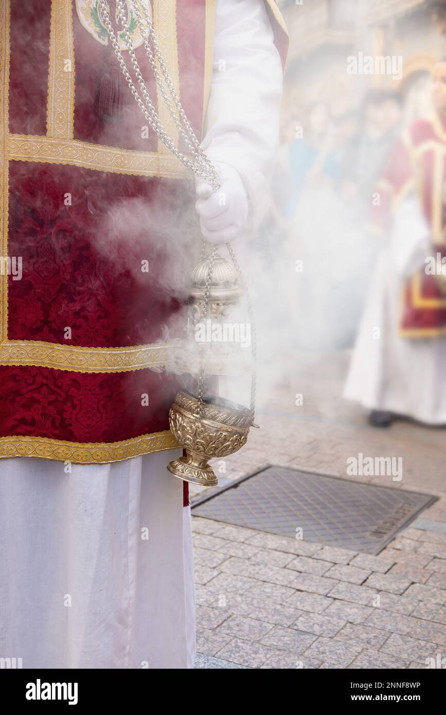 Zenser, der von einem Messdiener oder einem Akolyten während der Heiligen Woche geschüttelt wird, um Rauch und Duft von Weihrauch zu erzeugen Stockfoto