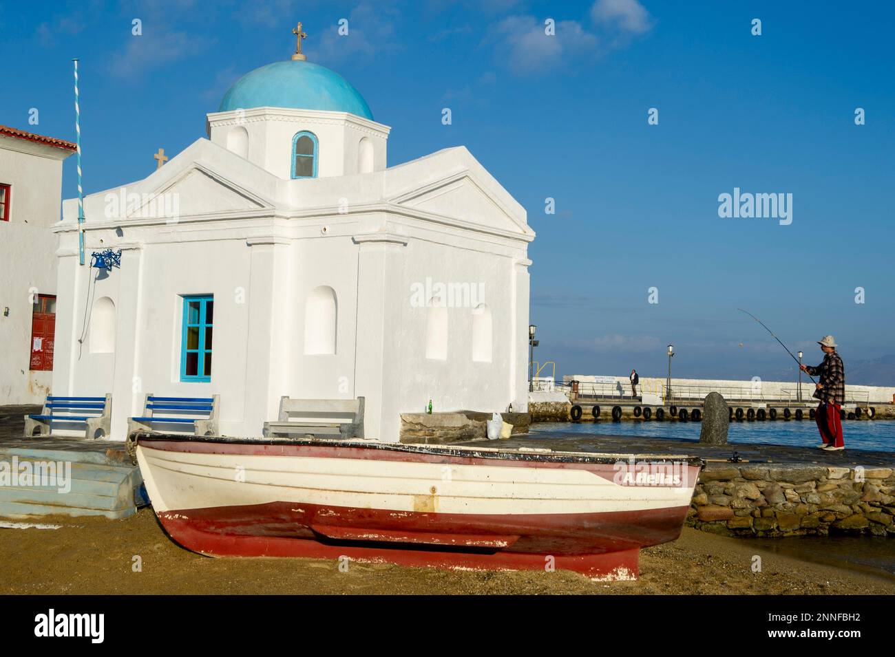 Europa, Griechenland, Mykonos. Ein Boot mit einem Fischer im Hintergrund auf Mykonos. Nur redaktionelle Verwendung. Stockfoto