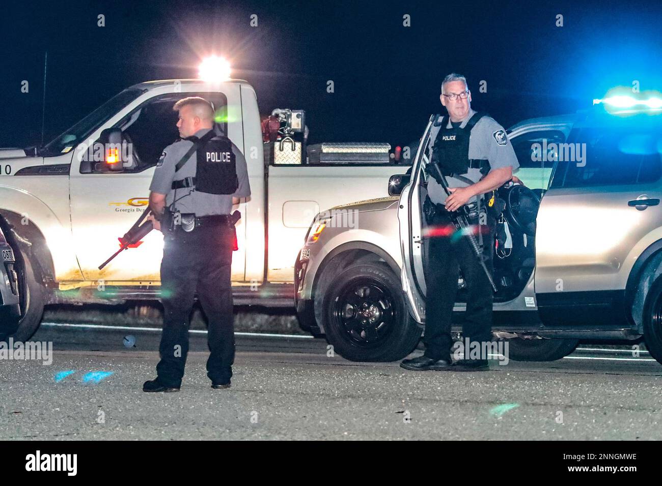 Police officers stand at the scene following a police chase Monday, April 12, 2021, in Carroll County, Ga. Georgia authorities say multiple officers were injured when the passenger of a car shot them during a police chase that ended with one suspect killed and the other arrested. (John Spink/Atlanta Journal-Constitution via AP) Stockfoto
