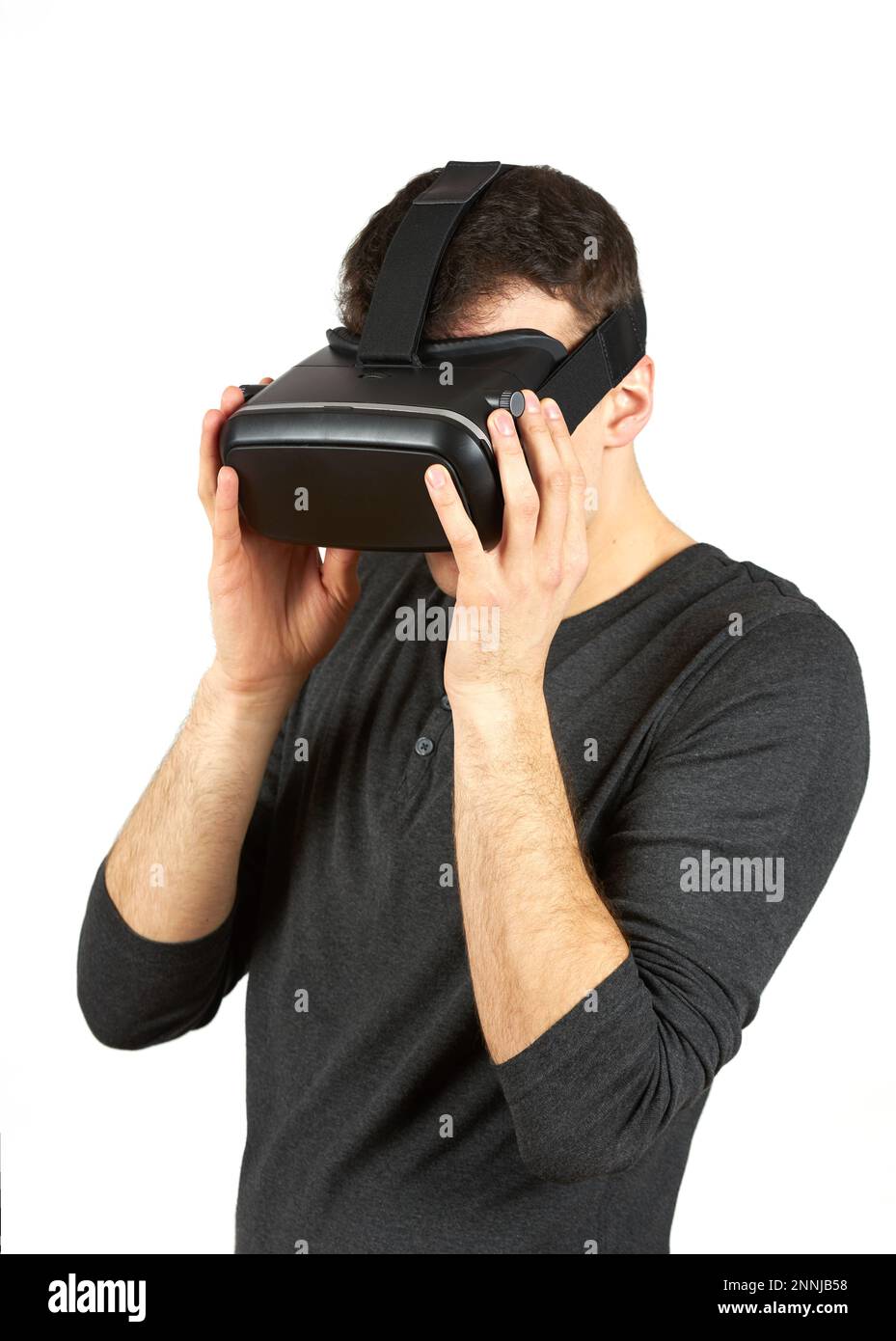 Ein junger Mann mit einem Virtual-Reality-Helm auf dem Kopf. Die Figur ist auf weißem Hintergrund isoliert. Stockfoto