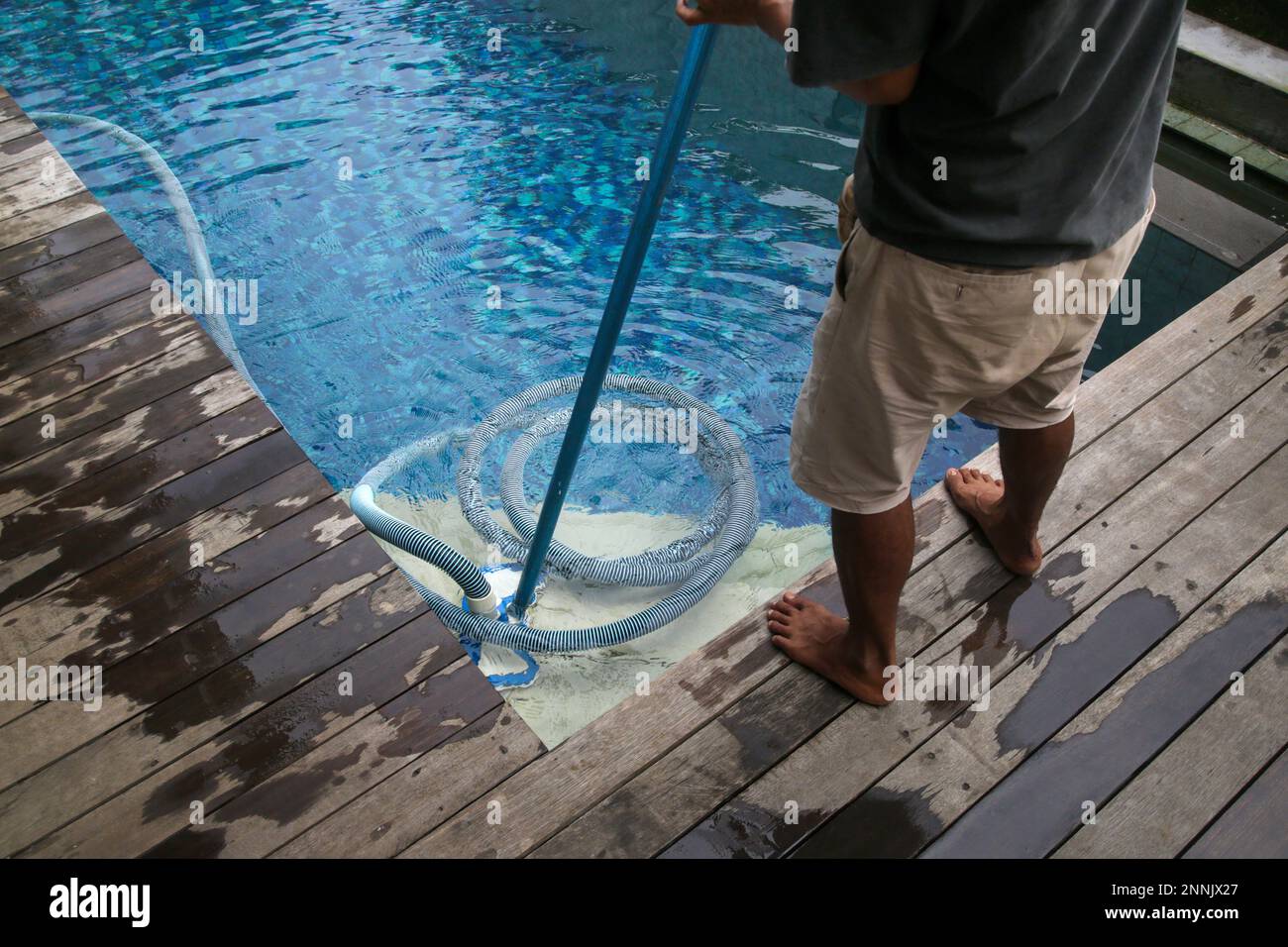 Mann reinigt Schwimmbad mit Staubsauger. Wöchentliche Wartung des Pools. Poolreinigung. Stockfoto