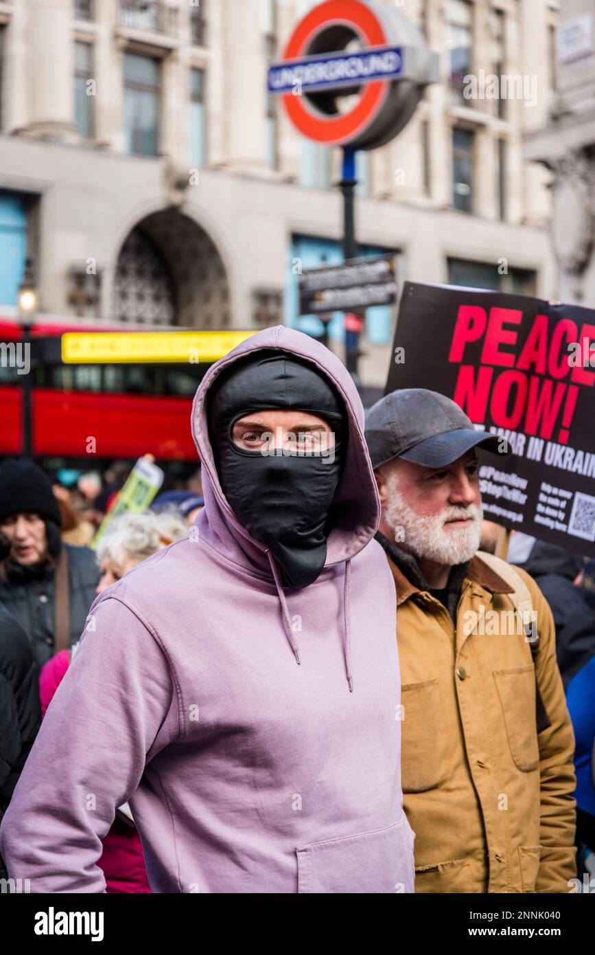 Mann mit einer Maske, Kampagne für nukleare Abrüstung (CND) und Stop the war Coalition Demonstration fordern das Ende des Krieges in der Ukraine, London, UK 25/02 Stockfoto