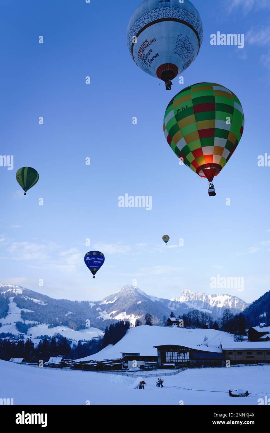 Heißluftballons hängen am Himmel über dem Chateau D'Oex Stockfoto