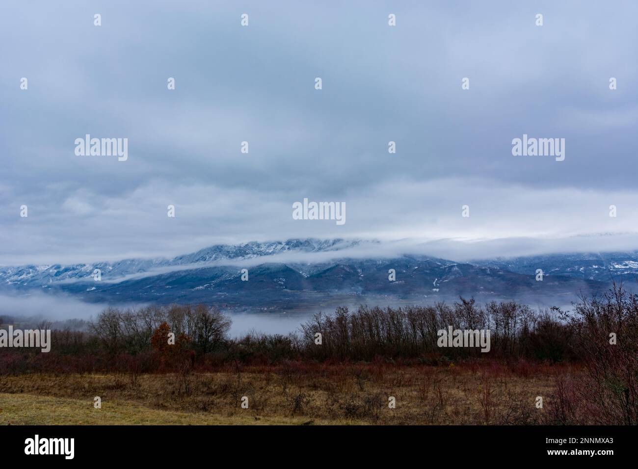 Eine fesselnde Winterlandschaft mit trockenen Bergen mit Schnee und Wolken sorgt für eine grandiose Kulisse Stockfoto