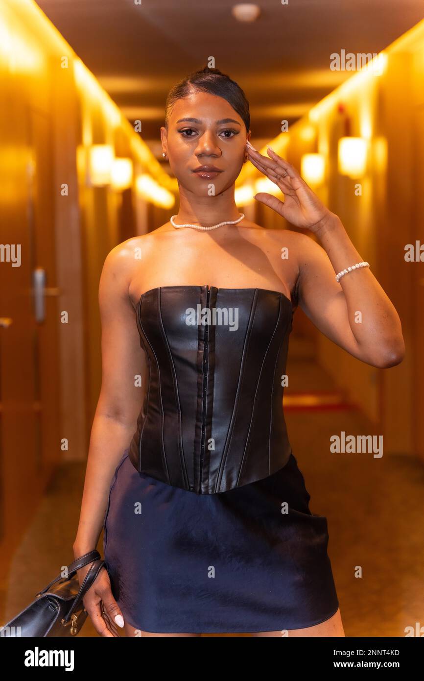 Mittelgroße Aufnahme einer reichen schwarzen ethnischen Frau, die sich im Hotelzimmerflur posiert, Luxuskonzept Stockfoto